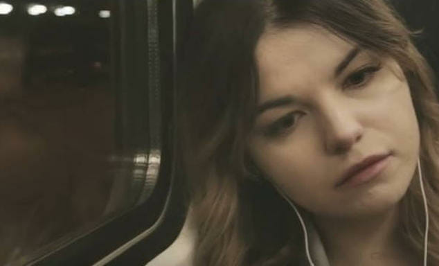 Cena do vídeo Vivendo com Depressão, de Kat Napiorkowska, onde ela está no ônibus, encostada no vidro, com ares de desanimada.