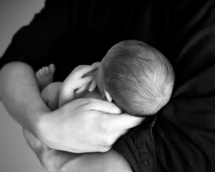 Imagem representando a depressão pós-parto: um pai segurando uma criança