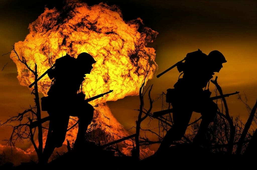 imagem mostrando uma explosão ao fundo e a silhueta de dois soldados. A imagem representa a guerra, uma das causas de transtorno de estresse pós-traumático