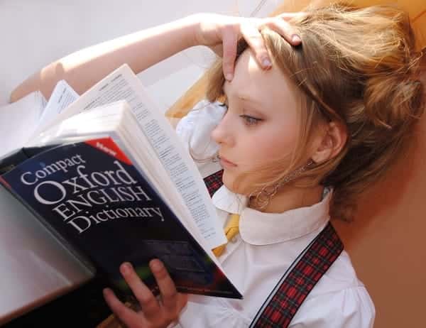 Foto mostra uma mulher lendo um livro, atividade que exige atenção.